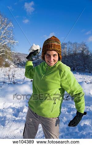 young woman playing with snowballs in a snow covered landscape View Large Photo Image Stock Photo - young woman playing with snowballs in a snow covered landscape. Fotosearch