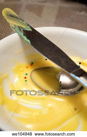 A bowl of homemade yellow icing with some sprinkles, a knife and a spoon View Large Photo Image Stock Photo - A bowl of homemade yellow icing with some sprinkles, a knife and a spoon. Fotosearch