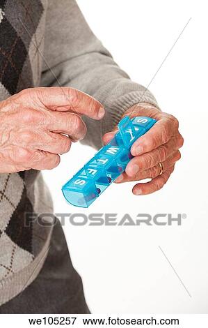 A Caucasian man getting his medicine out of a pill box on a white background View Large Photo Image Stock Photo - A Caucasian man getting his medicine out of a pill box on a white background. Fotosearch