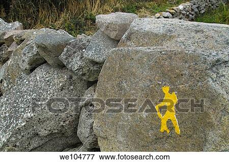 A yellow man painted on a stone wall as a waymarker on the Connemara Way, Co Galway, Ireland View Large Photo Image Stock Photo - A yellow man painted on a stone wall as a waymarker on the Connemara Way, Co Galway, Ireland. Fotosearch
