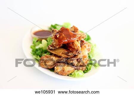 Stock Image - Barbecued chicken wings with sauce. Fotosearch