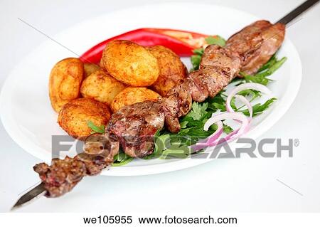 Char grilled Beef Shish Kebab Skewer with baked potatoes View Large Photo Image Stock Photography - Char grilled Beef Shish Kebab Skewer with baked potatoes. Fotosearch