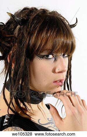 Close up of a young heavy metal fan girl with horns piercings and tattoos on a white background View Large Photo Image Stock Photo - Close up of a young heavy metal fan girl with horns piercings and tattoos on a white background. Fotosearch