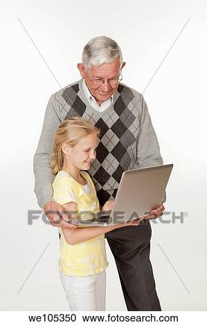 Cute Caucasian granddaughter showing her grandfather something on the computer View Large Photo Image Stock Image - Cute Caucasian granddaughter showing her grandfather something on the computer. Fotosearch