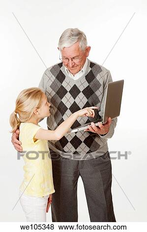 Cute Caucasian granddaughter showing her grandfather something on the computer View Large Photo Image Stock Photo - Cute Caucasian granddaughter showing her grandfather something on the computer. Fotosearch