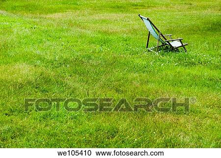 Stock Image - Empty Deck Chair on lawn, Sweden. Fotosearch