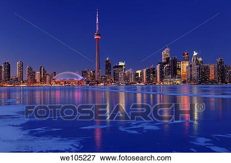 Stock Photo - Frozen ice covered Lake Ontario reflecting the lights of Toronto city skyline at dusk. Fotosearch