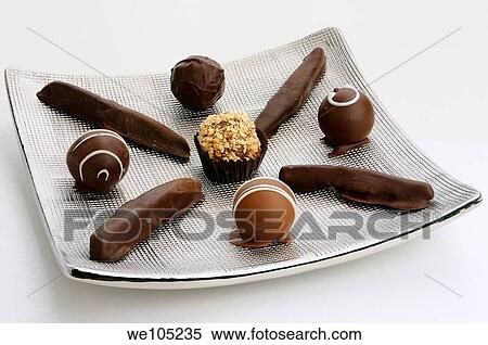 Hand made chocolate truffles and candied orange rind on a silver plate on white View Large Photo Image Stock Photography - Hand made chocolate truffles and candied orange rind on a silver plate on white. Fotosearch