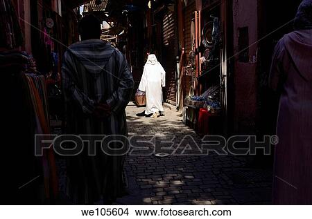 Old woman in white djellaba in a spotlight of sun in the narrow souk streets of Marrakech Morocco View Large Photo Image Picture - Old woman in white djellaba in a spotlight of sun in the narrow souk streets of Marrakech Morocco. Fotosearch