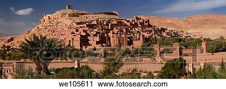 Stock Image - Panorama of Ait Benhaddou and blue berbers crossing Wadi Mellah near Ouarzazate Morocco. Fotosearch