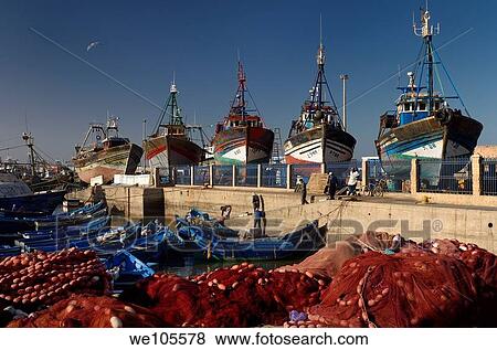 Red nets and fishermen getting ready to sail in the morning at the marine port of Essaouira Morocco View Large Photo Image Stock Photo - Red nets and fishermen getting ready to sail in the morning at the marine port of Essaouira Morocco. Fotosearch