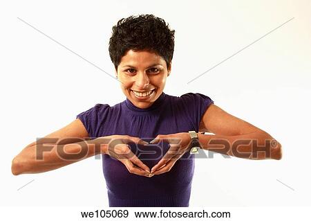 Smiling ethnic Canadian woman holding hands in heart shape over her chest View Large Photo Image Stock Photo - Smiling ethnic Canadian woman holding hands in heart shape over her chest. Fotosearch