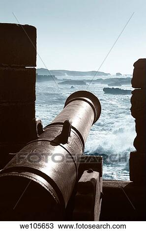 Stock Image - Two toned image of a cannon on the Essaouira ramparts facing the Atlantic ocean coast. Fotosearch