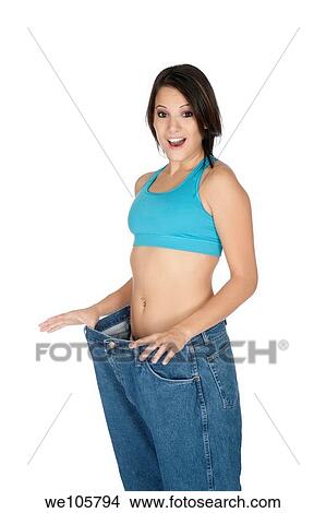Woman showing weight loss by wearing an old pair of jeans View Large Photo Image Picture - Woman showing weight loss by wearing an old pair of jeans. Fotosearch