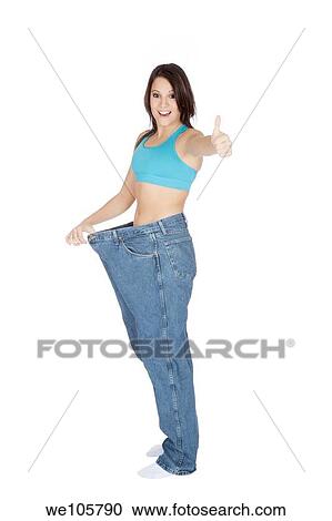 Woman showing weight loss by wearing an old pair of jeans View Large Photo Image Stock Image - Woman showing weight loss by wearing an old pair of jeans. Fotosearch
