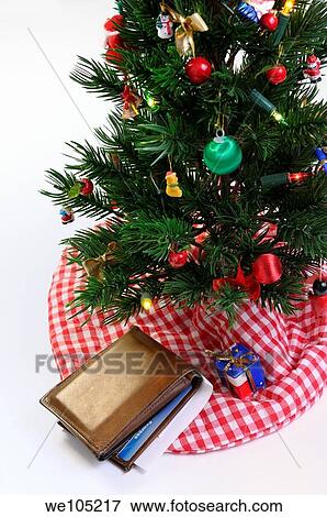 Worn wallet with charge cards and check under the decorated Christmas tree View Large Photo Image Stock Photo - Worn wallet with charge cards and check under the decorated Christmas tree. Fotosearch