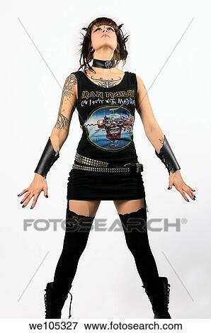 Young heavy metal female punk fan standing tall with horns piercings and tattoos on a white background View Large Photo Image Stock Photo - Young heavy metal female punk fan standing tall with horns piercings and tattoos on a white background. Fotosearch