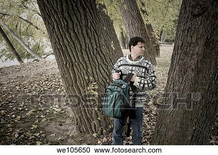 Young man, with backpack, in the woods View Large Photo Image Stock Image - Young man, with backpack, in the woods. Fotosearch