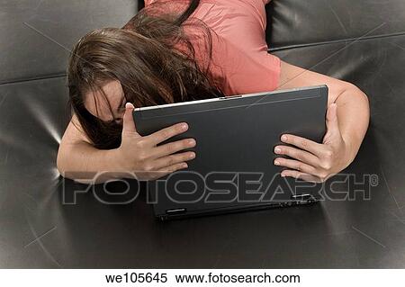 Young woman lying on a mat, working on her laptop computer View Large Photo Image Stock Photography - Young woman lying on a mat, working on her laptop computer. Fotosearch
