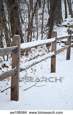 A snow covered fence along a path in the forest View Large Photo Image Picture - A snow covered fence along a path in the forest. Fotosearch