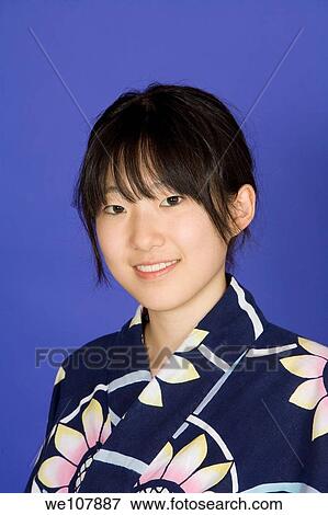 Asian teen dressed in a Kimono on a blue background View Large Photo Image Stock Photo - Asian teen dressed in a Kimono on a blue background. Fotosearch