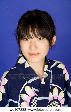 Asian teen dressed in a Kimono on a blue background View Large Photo Image Stock Photo - Asian teen dressed in a Kimono on a blue background. Fotosearch
