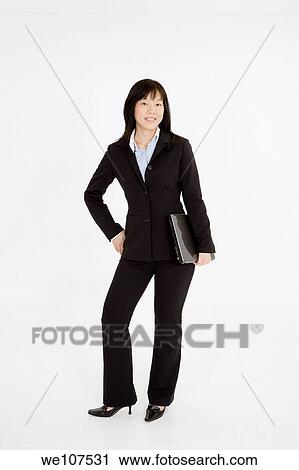 Beautiful Asain Businesswoman posing on a white background holding a laptop View Large Photo Image Stock Image - Beautiful Asain Businesswoman posing on a white background holding a laptop. Fotosearch