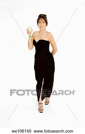 Beautiful Brazilian or Hispanic holding a glass of white wine in a black evening gown on a white background View Large Photo Image Stock Image - Beautiful Brazilian or Hispanic holding a glass of white wine in a black evening gown on a white background. Fotosearch