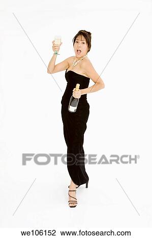 Beautiful Brazilian or Hispanic holding a glass of white wine or champagne in a black evening gown on a white background View Large Photo Image Stock Image - Beautiful Brazilian or Hispanic holding a glass of white wine or champagne in a black evening gown on a white background. Fotosearch