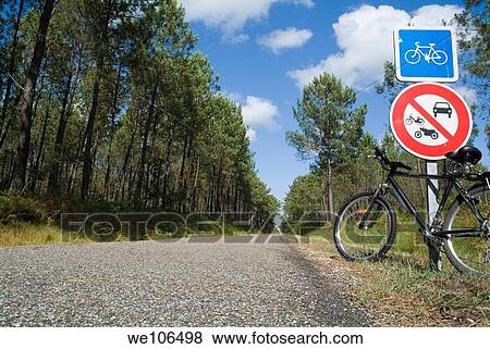 Bicycle parked against a road sign on a bicycle track passing through the Landes forest, France View Large Photo Image Stock Photo - Bicycle parked against a road sign on a bicycle track passing through the Landes forest, France. Fotosearch