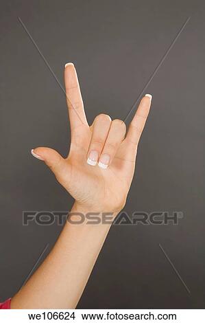 Caucasian female using hand gestures to say I love you View Large Photo Image Picture - Caucasian female using hand gestures to say I love you. Fotosearch