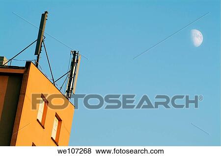 Stock Photo - Cellular phone antennas and a half moon at sunset, Bordeaux, France. Fotosearch