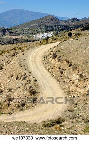 Stock Image - Dirt road winding above Capileira village in the Alpujarras mountains, Andalusia, Spain. Fotosearch
