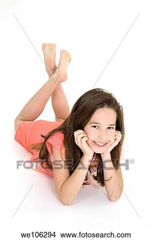 Eight year old female child laying on white background smiling wearing casual clothes View Large Photo Image Picture - Eight year old female child laying on white background smiling wearing casual clothes. Fotosearch