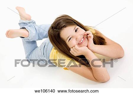 Stock Image - Five year old female child laying on white background smiling wearing casual clothes. Fotosearch