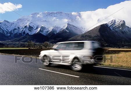 Four wheel drive car travelling along a road with snowcapped mountains in the background View Large Photo Image Stock Photograph - Four wheel drive car travelling along a road with snowcapped mountains in the background. Fotosearch
