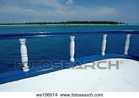 Picture - Idyllic Paradise Island seen from a boat deck in the sea, Maldives. Fotosearch