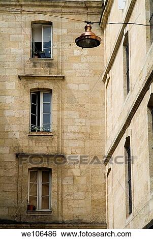 Lantern hanging from a wire with apartment buildings in the background, Bordeaux, France View Large Photo Image Stock Photograph - Lantern hanging from a wire with apartment buildings in the background, Bordeaux, France. Fotosearch