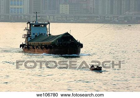 Large barge behind a tiny fishing boat crossing the Victoria Harbor, Hong Kong, China View Large Photo Image Stock Image - Large barge behind a tiny fishing boat crossing the Victoria Harbor, Hong Kong, China. Fotosearch