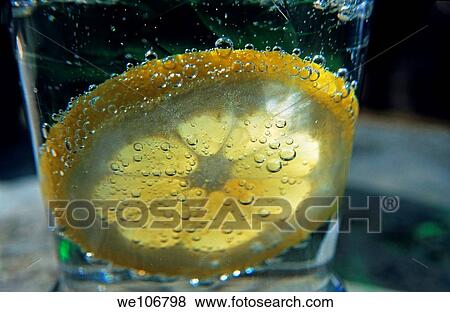 Stock Photo - Lemon slice floating in a fizzy drink. Fotosearch