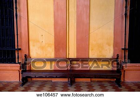 Long wooden bench against a yellow wall at the Alcazar of Seville, Seville, Andalusia, Spain View Large Photo Image Stock Photo - Long wooden bench against a yellow wall at the Alcazar of Seville, Seville, Andalusia, Spain. Fotosearch