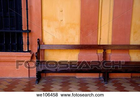 Long wooden bench against a yellow wall at the Alcazar of Seville, Seville, Andalusia, Spain View Large Photo Image Stock Photo - Long wooden bench against a yellow wall at the Alcazar of Seville, Seville, Andalusia, Spain. Fotosearch