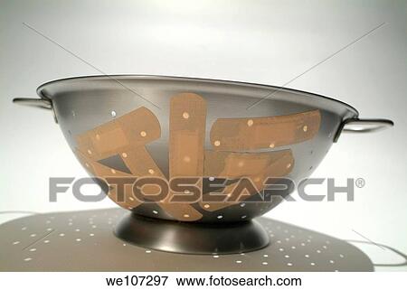 Stock Photo - Metallic colander covered with sticking plasters. Fotosearch