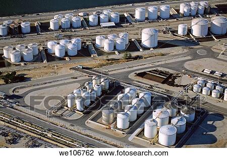 Stock Image - Oil tanks next to sea with railroad tracks. Fotosearch