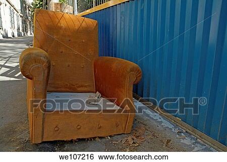 Old orange armchair is left abandoned in a city street View Large Photo Image Stock Photograph - Old orange armchair is left abandoned in a city street. Fotosearch