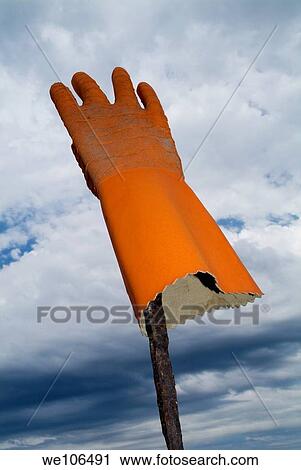 Orange rubber glove on a wooden post against a cloudy sky, France View Large Photo Image Stock Image - Orange rubber glove on a wooden post against a cloudy sky, France. Fotosearch