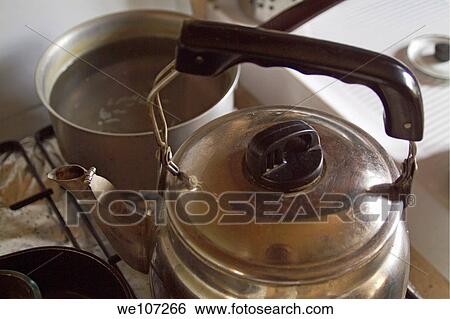 Pan fill of liquid and a teapot on a cooker stove View Large Photo Image Stock Photograph - Pan fill of liquid and a teapot on a cooker stove. Fotosearch