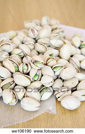 Stock Image - Pistachio Nuts on wax paper. Fotosearch