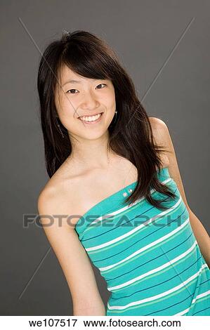 Portrait of a beautiful Asian teenager posing on a gray background with some attitude View Large Photo Image Stock Photo - Portrait of a beautiful Asian teenager posing on a gray background with some attitude. Fotosearch