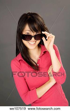Portrait of a beautiful Asian teenager posing on a gray background View Large Photo Image Stock Photo - Portrait of a beautiful Asian teenager posing on a gray background. Fotosearch